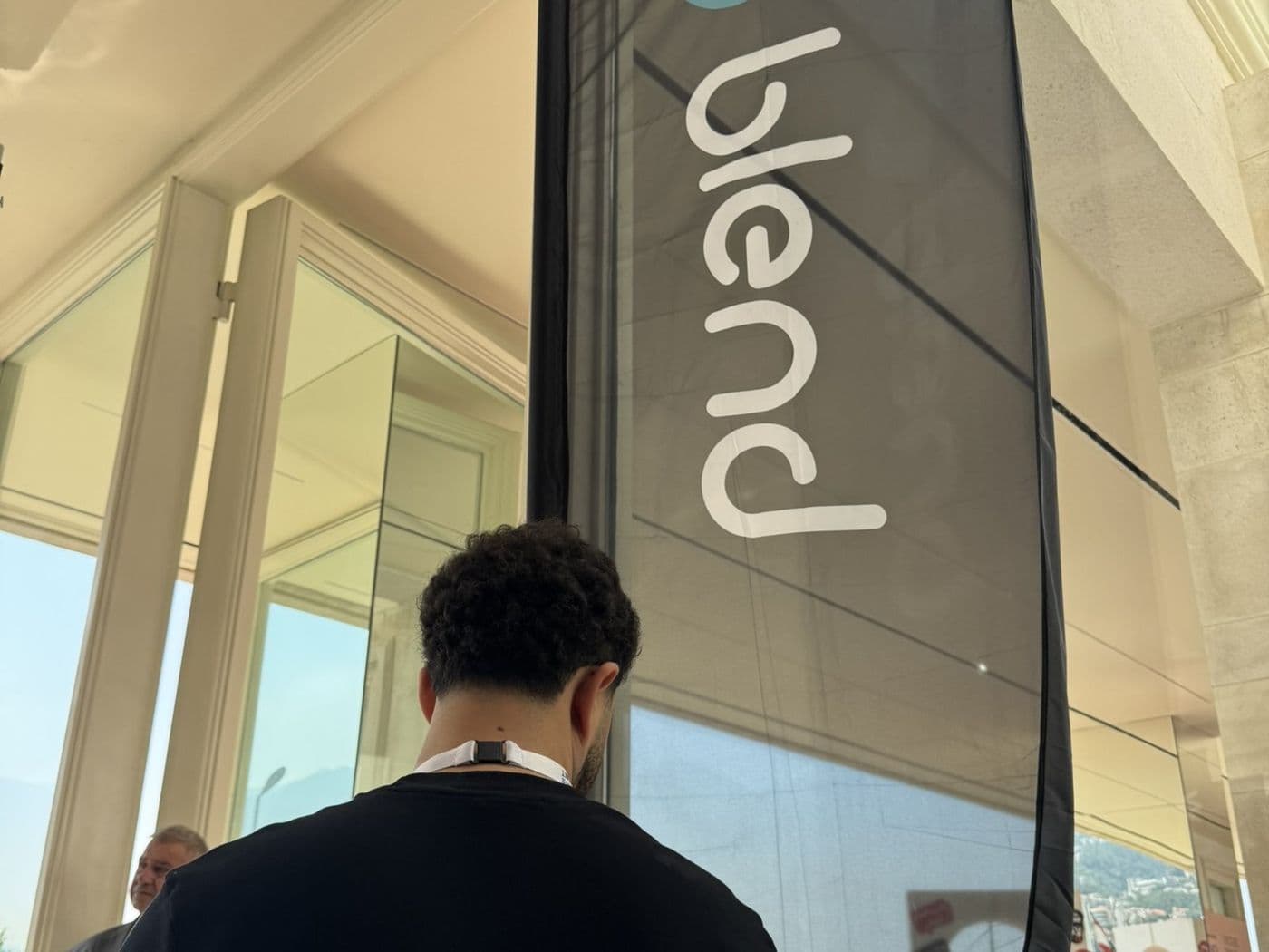 A Blend banner at the entrance of Théâtre Casino du Liban, with a Blend team member in a black Blend shirt walking in