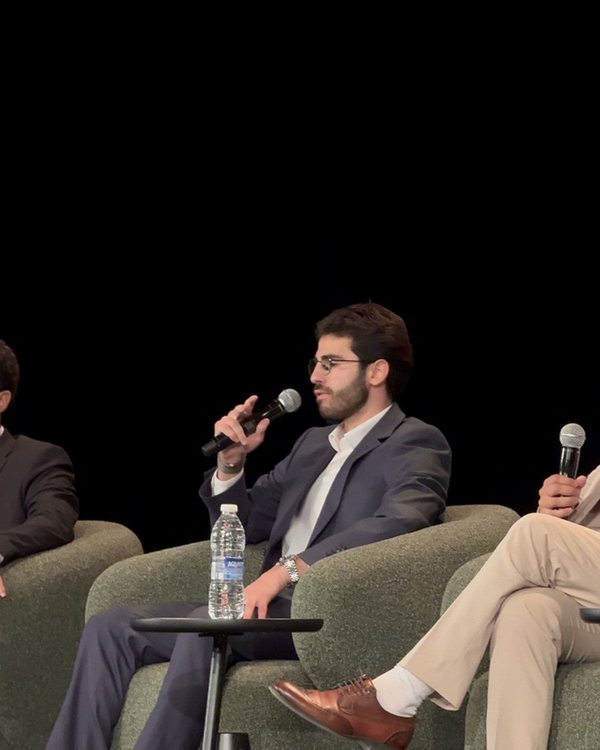 A panel speaker answering a question with a microphone on the main stage