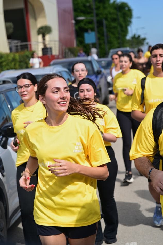 Two women running together, one in a yellow Sabah El Kheir Run t-shirt