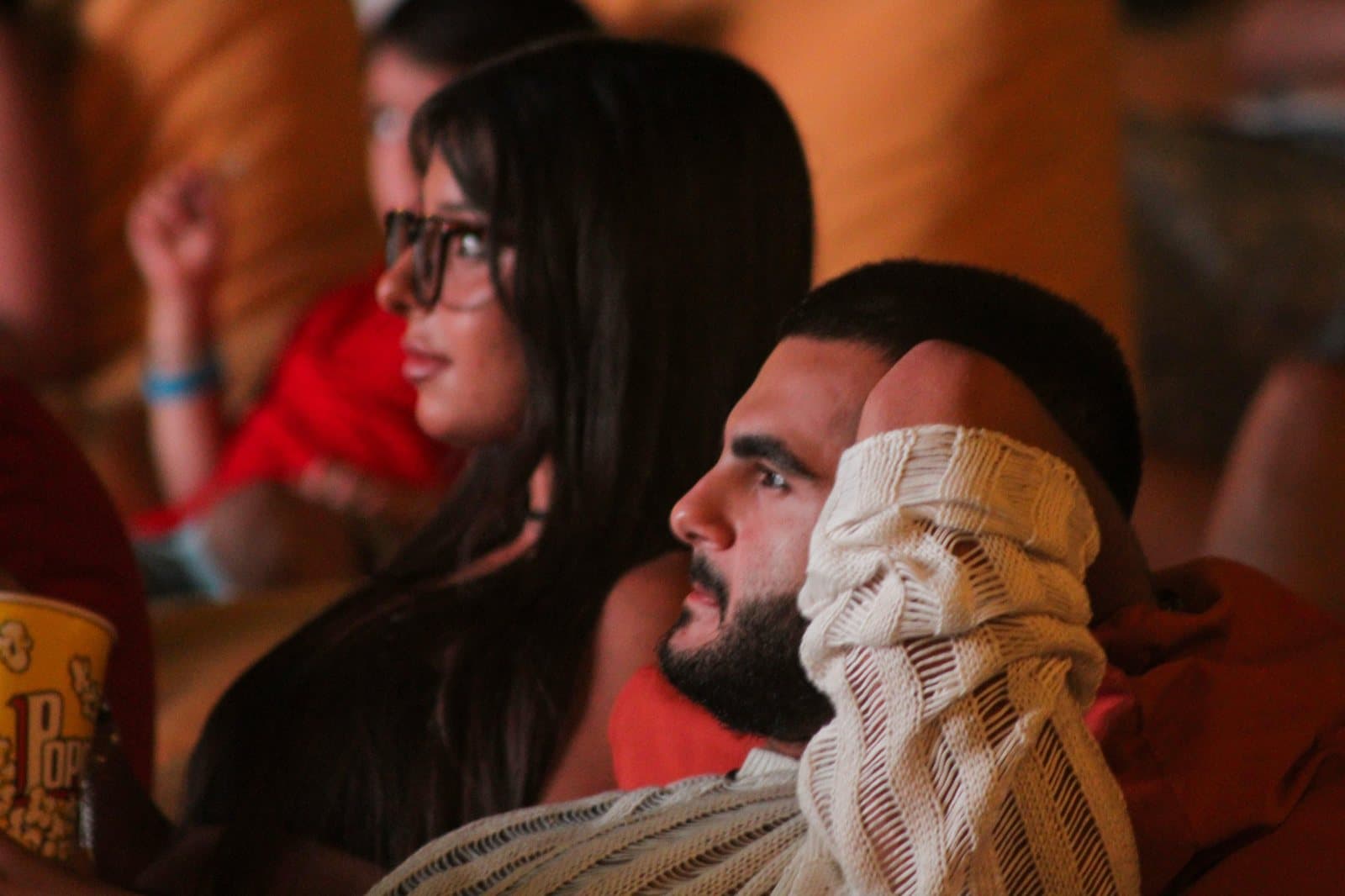 Close-up of two guests watching the screen from their beanbags at night